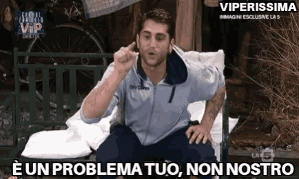 a man is sitting on a bench talking on a cell phone and says e un problema tuo non nostro .