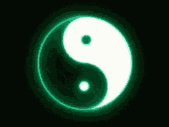 a green and white yin yang symbol is glowing in the dark on a black background .