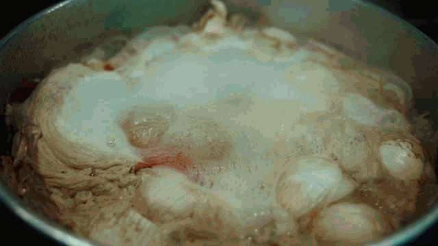 eggs are boiling in a pot of water on a stove top