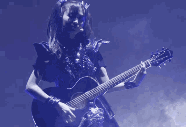 a woman is playing a guitar with the word taylor on the neck