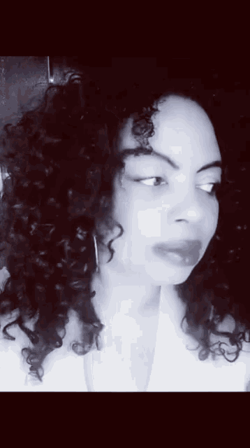 a woman with curly hair looks at the camera