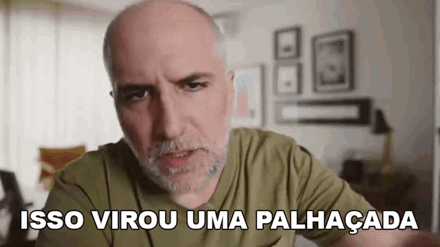 a bald man with a beard is making a funny face and says `` isso virou uma palhaçada '' .