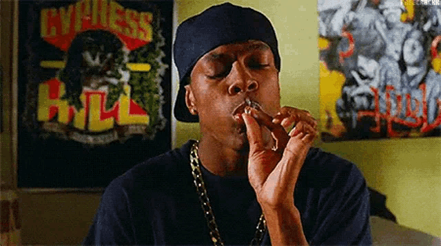 a man is smoking a cigarette in front of a painting of a man smoking a cigarette .