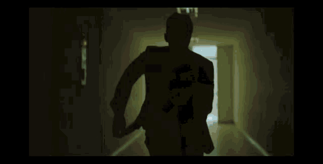 a man in a suit is running through a hallway