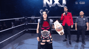 a woman in a wrestling ring holding a belt with nxt written on it