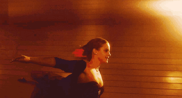 a woman in a black dress stands in front of a red exit sign