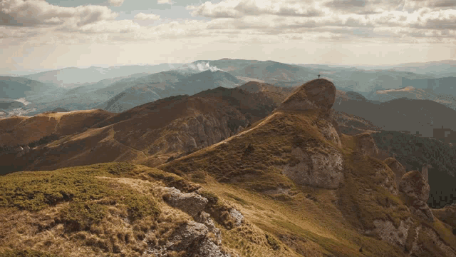 a person standing on top of a mountain looking out over a valley