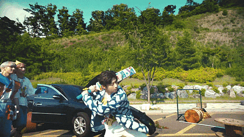 a man in a blue and white shirt is holding a baseball bat