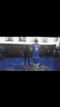 a man in a blue shirt with the number 7 on it is fighting another man