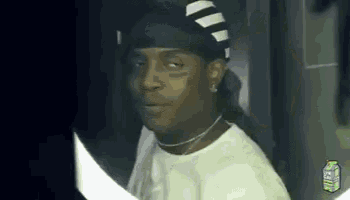 a man wearing a headband and a necklace is standing in front of a mirror .
