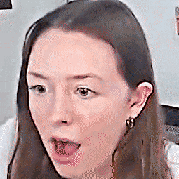 a close up of a woman 's face with her mouth open and a surprised look on her face .
