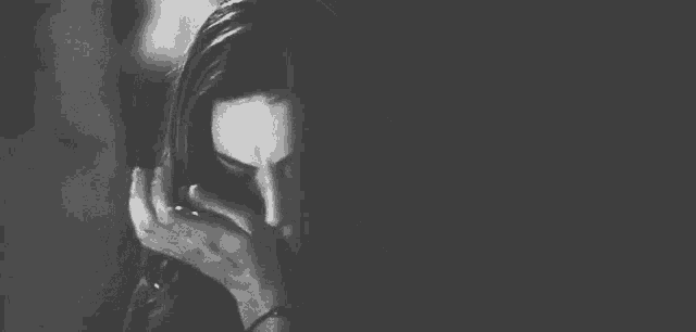 a black and white photo of a woman crying with her eyes closed