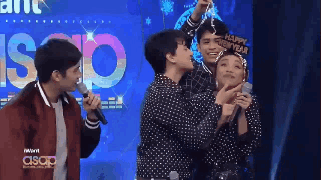 a group of people on a stage with a sign that says happy new year on it
