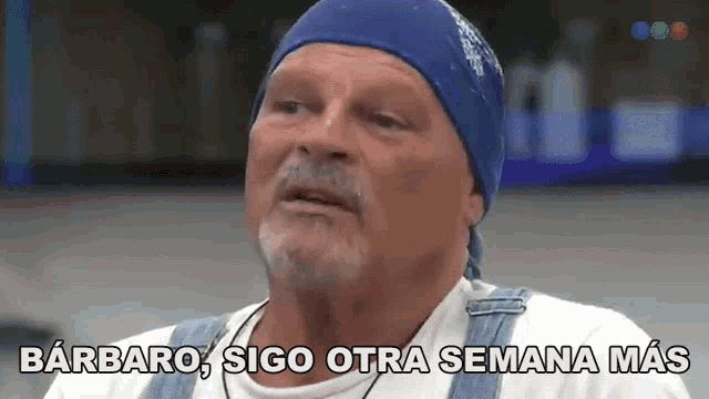 a man wearing a bandana and overalls says barbaro sigo otra semana más