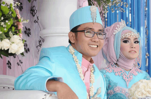 a bride and groom are posing for a picture and the bride is wearing a purple hijab