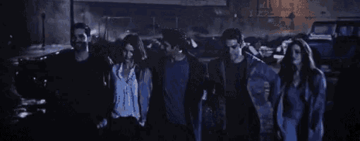 a group of people standing next to each other in the dark .