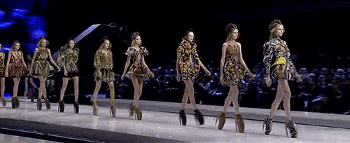 a group of women are walking down a runway wearing heels