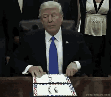 donald trump is sitting at a table with a cake that says " i love fucking president " on it