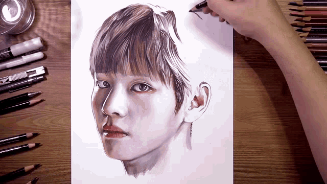 a person is drawing a woman 's face with colored pencils on a wooden table