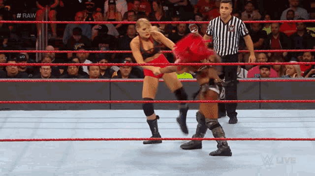 two women are wrestling in a ring with a referee and the words raw live on the bottom