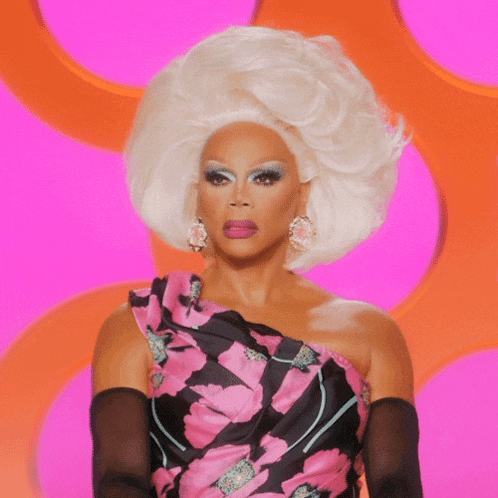 a drag queen says " the f * ck " while wearing a pink and black dress