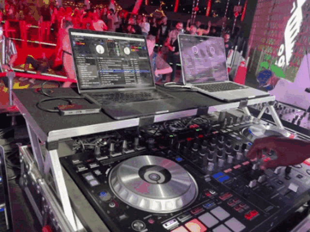 a dj playing music with a laptop on top of a mixer