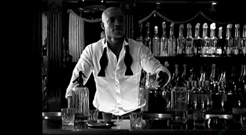 a bartender is pouring a drink into a glass