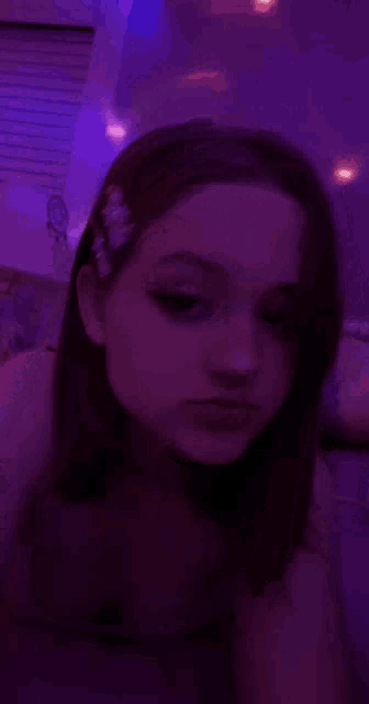 a girl taking a selfie in a dark room with purple lights