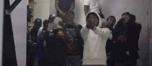a group of young men are standing in a room and making funny faces .