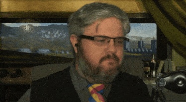 a man with a beard and glasses is wearing ear buds