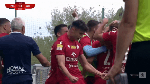 a group of soccer players are celebrating a goal against a team that has the number 2 on their jersey
