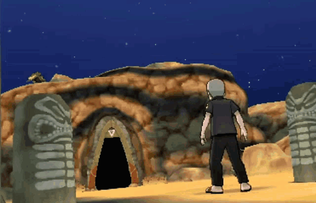 a man in a black shirt stands in front of a cave in the desert