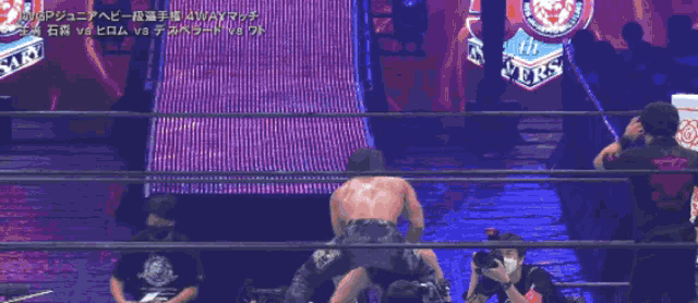 two men are wrestling in a ring with a sign that says wgp