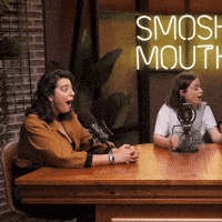 two women are sitting at a table with microphones and a sign that says smosh mouth