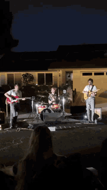 a blurry picture of people playing instruments in front of a building at night