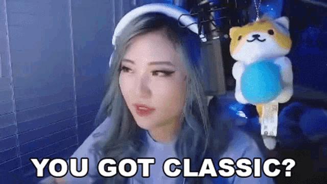 a woman is sitting in front of a microphone with a stuffed animal hanging from her neck and says `` you got classic '' .
