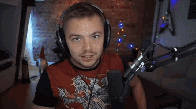 a man wearing headphones and a red shirt with a dragon on it