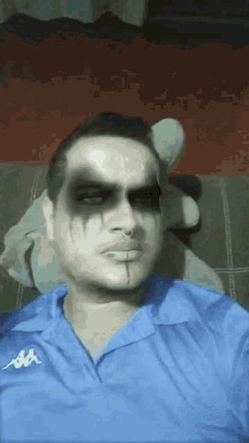 a man wearing a blue shirt with kappa on it is making a funny face