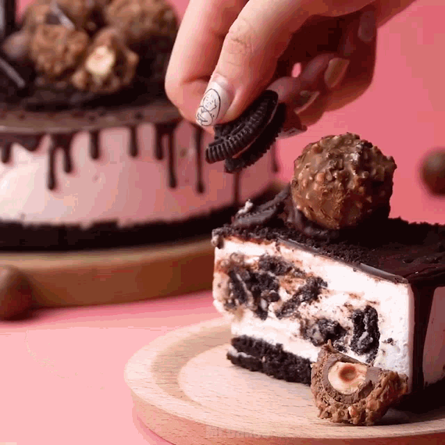 a person is holding an oreo cookie over a piece of cake