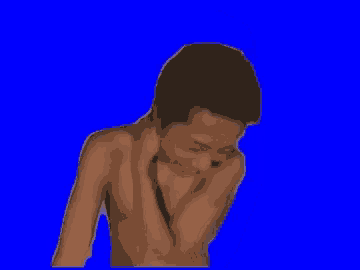 a shirtless man is sitting in front of a blue background .