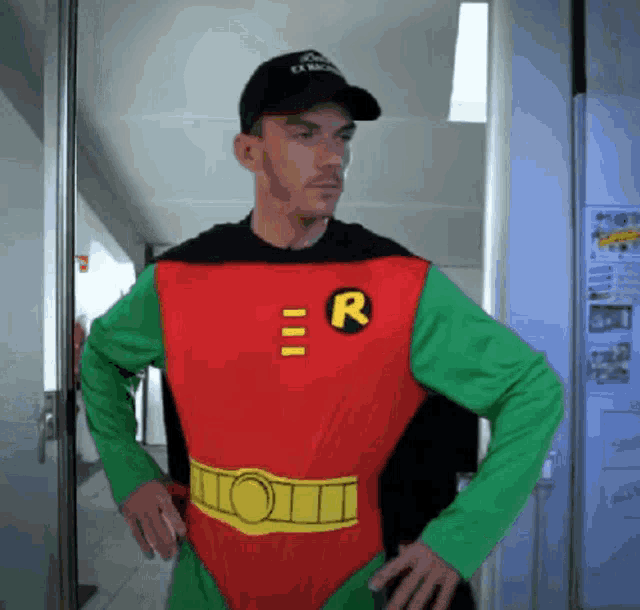 a man in a robin costume with the letter r on the chest
