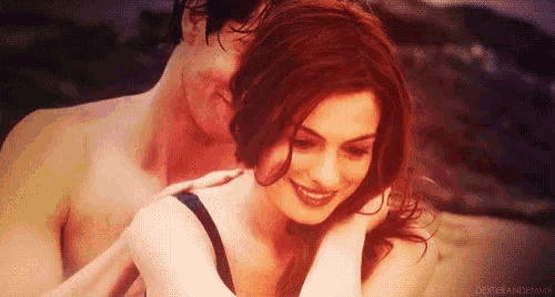 a man and woman are hugging each other on the beach .