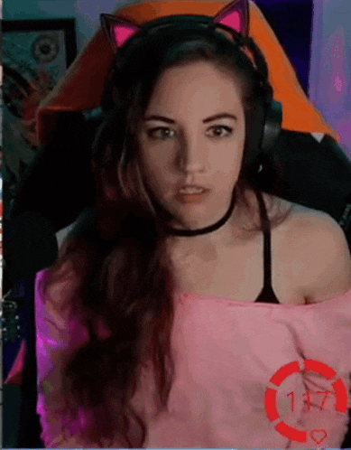 a woman is wearing headphones and a choker while sitting in a chair .