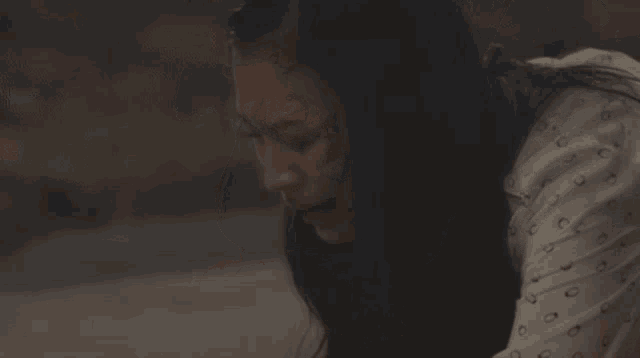 a woman in a white shirt is hugging a dog and crying