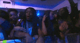 a group of young women are sitting in a crowd at a concert .