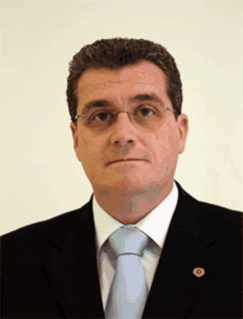 a man in a suit and tie has a badge on his jacket