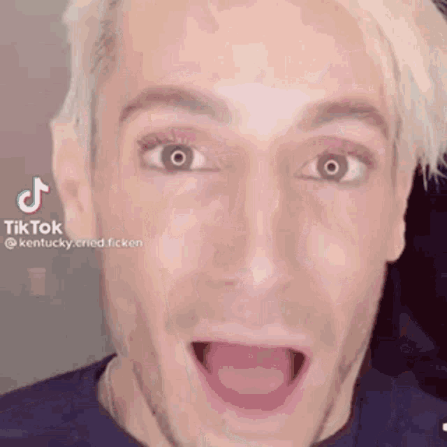 a close up of a man 's face with his mouth open and his eyes wide open .