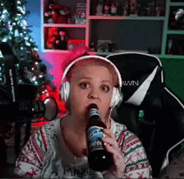 a woman wearing headphones is drinking a beer