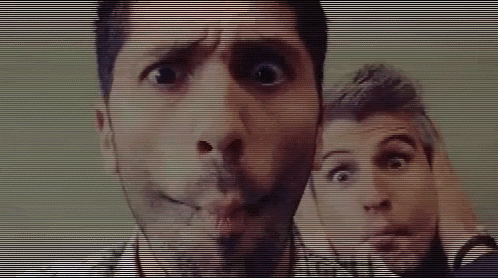 a man with a beard is making a funny face next to another man who is making a funny face .