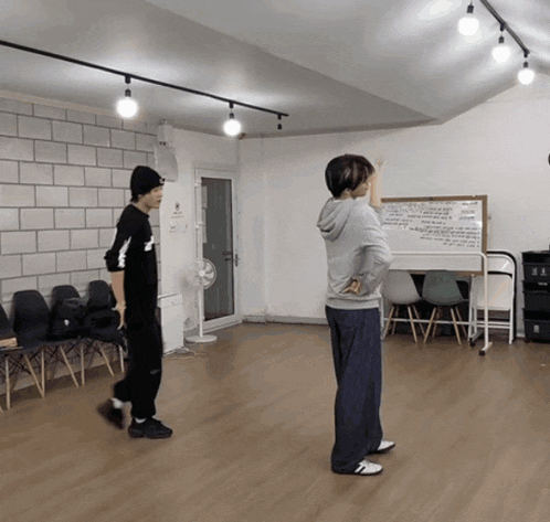 two people are standing in a room with a white board that says ' a few steps ' on it